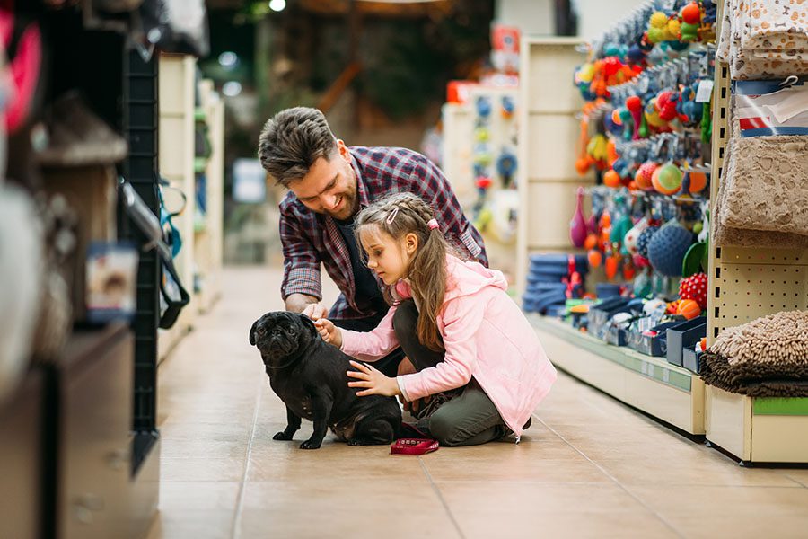 Pet Store Insurance - Father and Daughter in the Pet Store with Their Dog